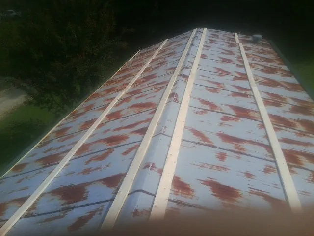 Rusted metal roof panels with new wood purlins before replacement — Storm Damage Roof Repair in Joelton by Roofing Brothers