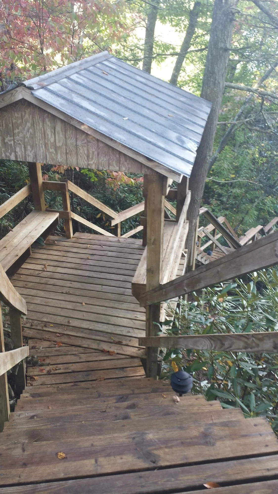 Metal roofed shelter over wooden steps on a wooded walkway — Skylight Repair & Installation work by our crew in Joelton