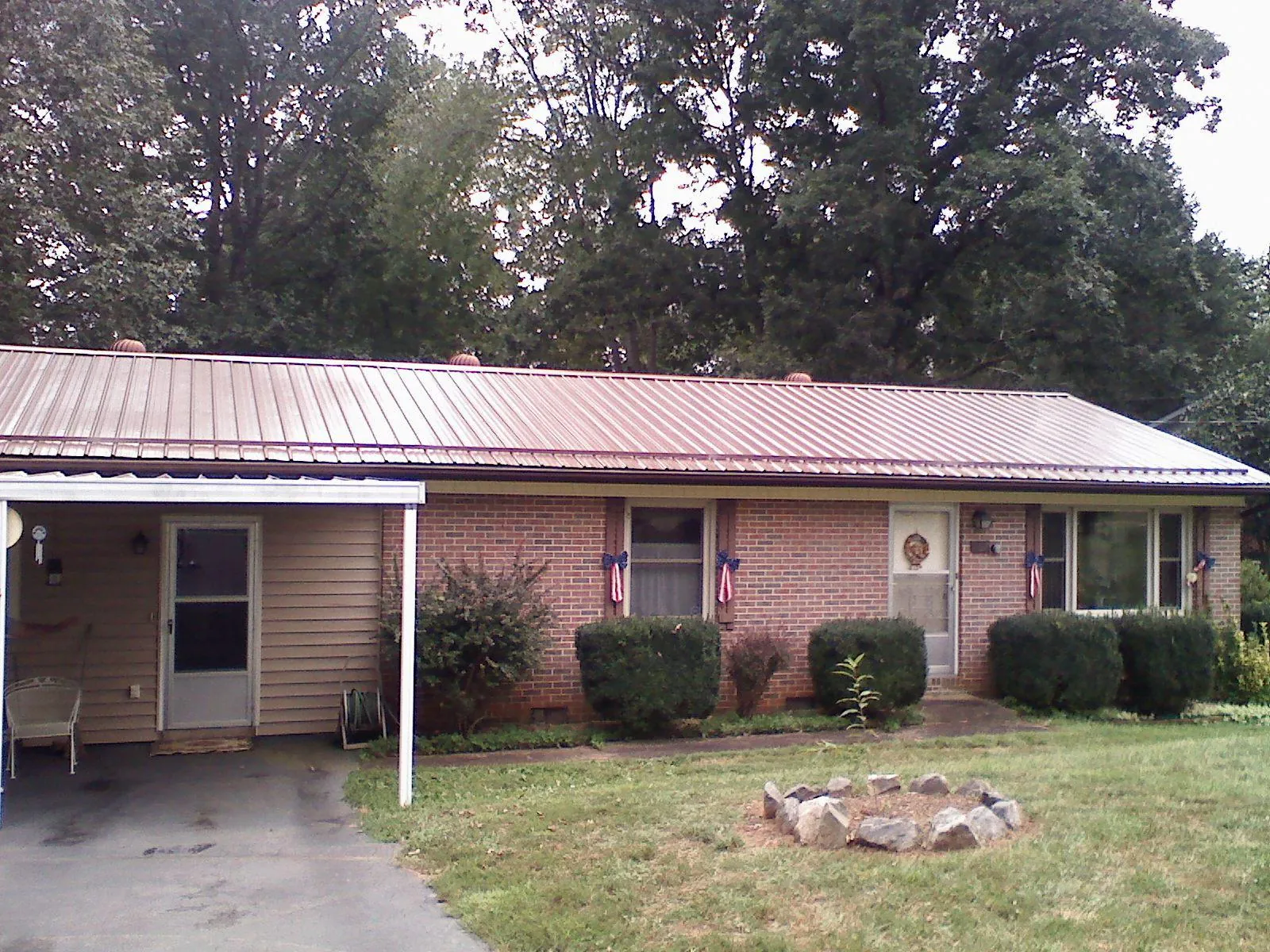 Bronze metal roof and carport on a brick ranch home — Roof Repair work by our crew in Joelton